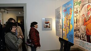 Besucherinnen und Besucher gehen durch die Ausstellung.