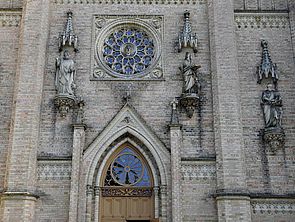 Die Westfassade schmücken eine Fensterrose und die vier Evangelisten Matthäus, Markus, Lukas und Johannes.