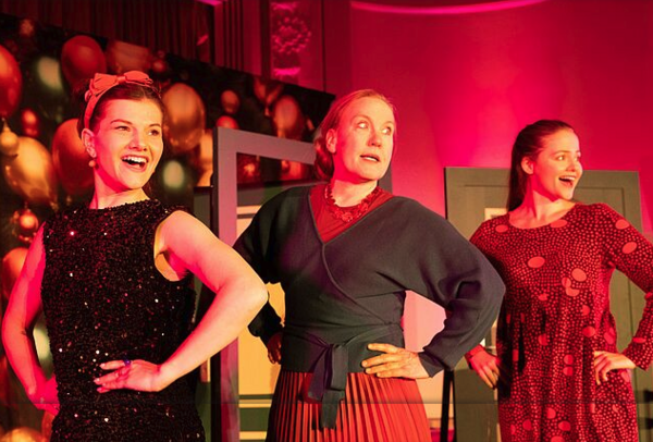 Drei Frauen singen und tanzen auf der Bühne.