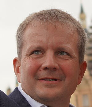 Rico Badenschier lächelt. Im Hintergrund das Schweriner Schloss.