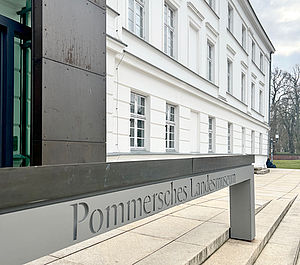 Ein grauer Steg vor dem Eingang mit der Aufschrift Pommersches Landesmuseum