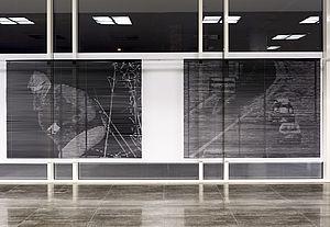 Zwei schwarze Installationen in einem großen, weißen Rahmen. 