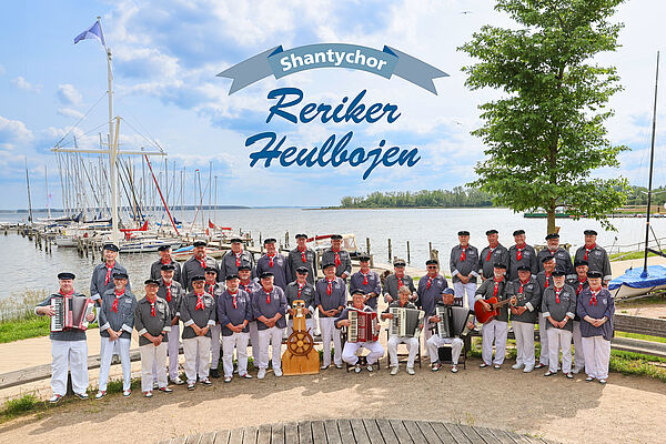 Gruppenfoto eines Shanty-Chors am Wasser.