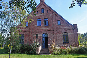 Ein dreigeschossiges Backsteinhaus von außen.