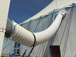 Ein Schlauch. Der Schlauch führt von außen ins Zelt.