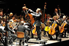 Daniel Huppert dirigiert das Orchester.