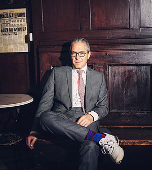 Ein Mann sitzt auf einem Stuhl.