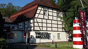 Ein weißes Fachwerkhaus mit rotem Dach.