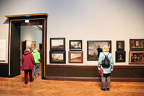 Besucher betrachten Bilder im Museum.