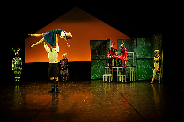 Das Foto zeigt ein Ballett auf einer Bühne. Ein Mann hebt eine Frau hoch.