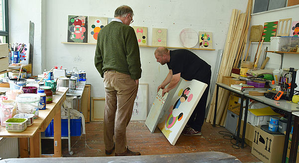 Hendrik Silbermann zeigt einem Mitglied der Kunstkommission in seinem Atelier seine Arbeiten.