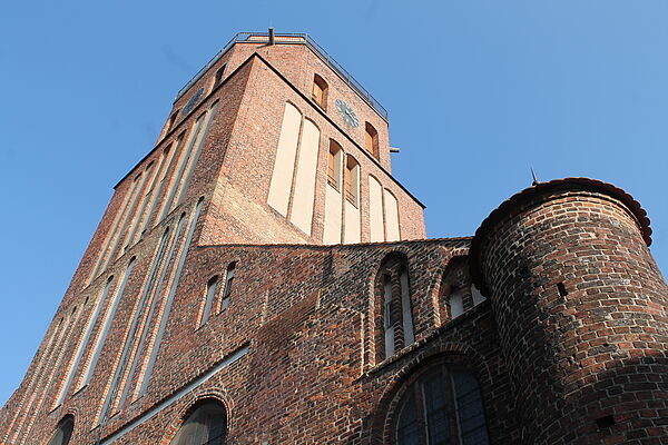 Ein Kirchenturm vor blauem Himmel.