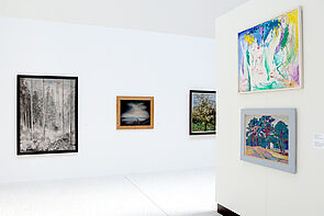 Fünf Bilder, mal groß, mal klein, hängen an der Wand.