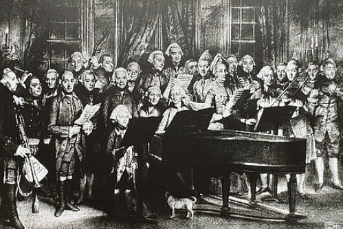 Ein altes Foto zeigt Musiker rund um einem Klavier.