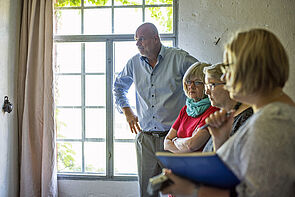 Drei Mitglieder der Kunstkommission und der Künstler stehen nebeneinander.