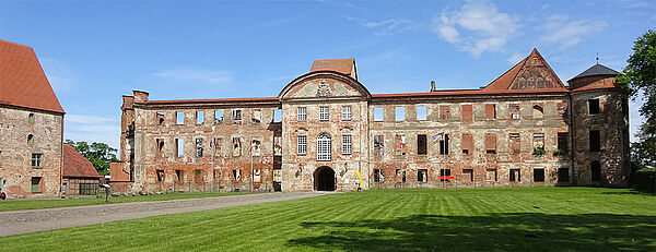 Eine Backstein-Ruine mit vielen offenen Fenstern. 