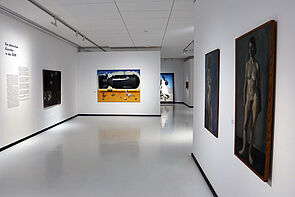 Großformatige Bilder hängen an Ausstellungswänden.
