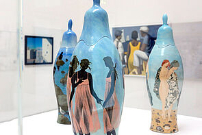 Drei Vasen im Vordergrund. Darauf zu sehen: Strand-Motive.