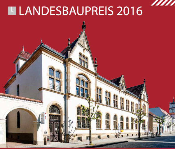 Auf rotem Hintergrund befindet sich eine Außenaufnahme vom Kulturquartier. Darüber steht in weißer Schrift "Landesbaupreis 2016".