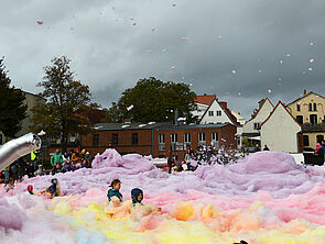 Kinder baden im großen Schaumfeld.