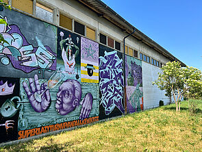 Eine Hallenwand mit Grafitti.