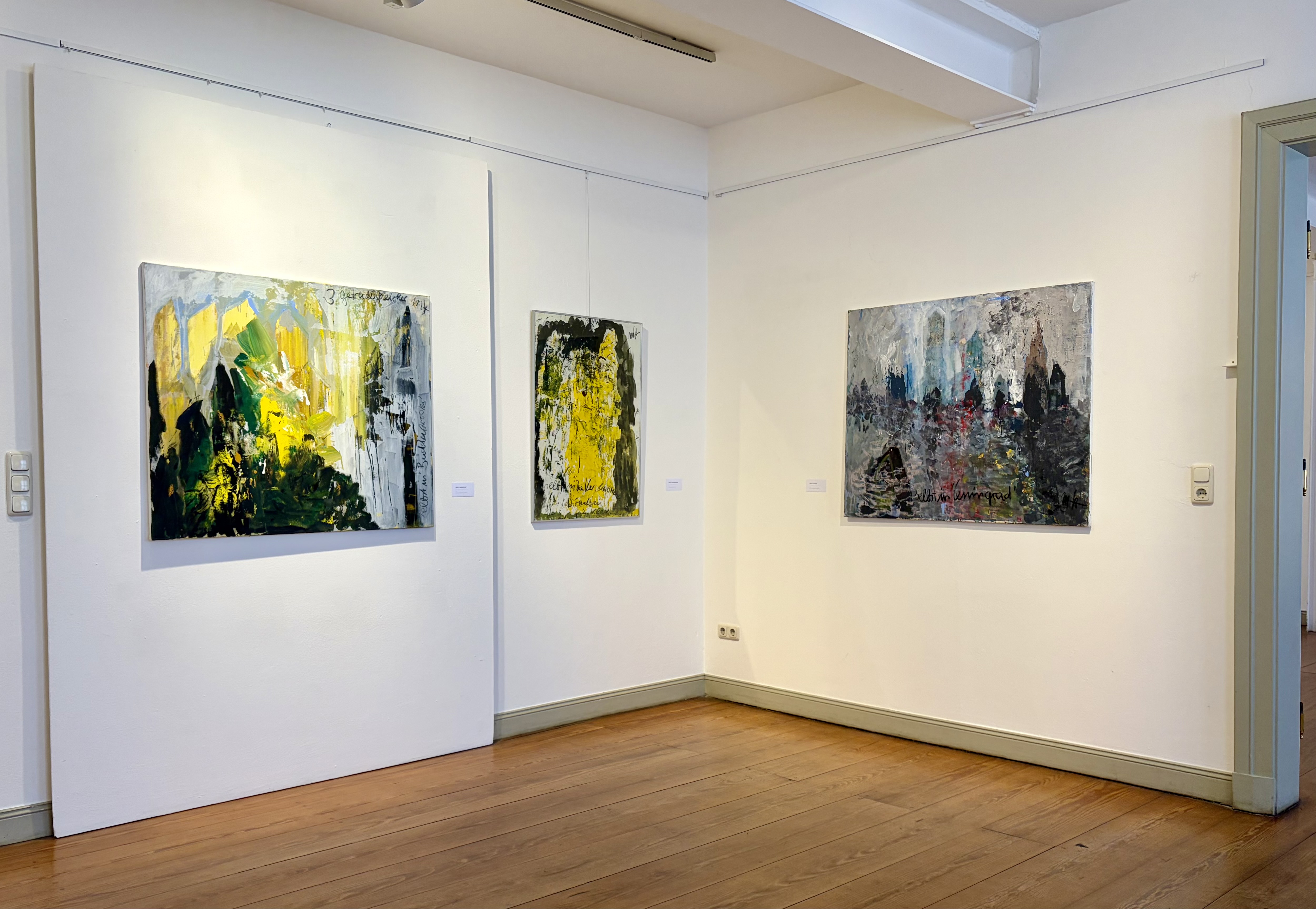 Drei Bilder hängen an der Wand.