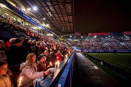 Tausende Menschen singen gemeinsam im Stadion.